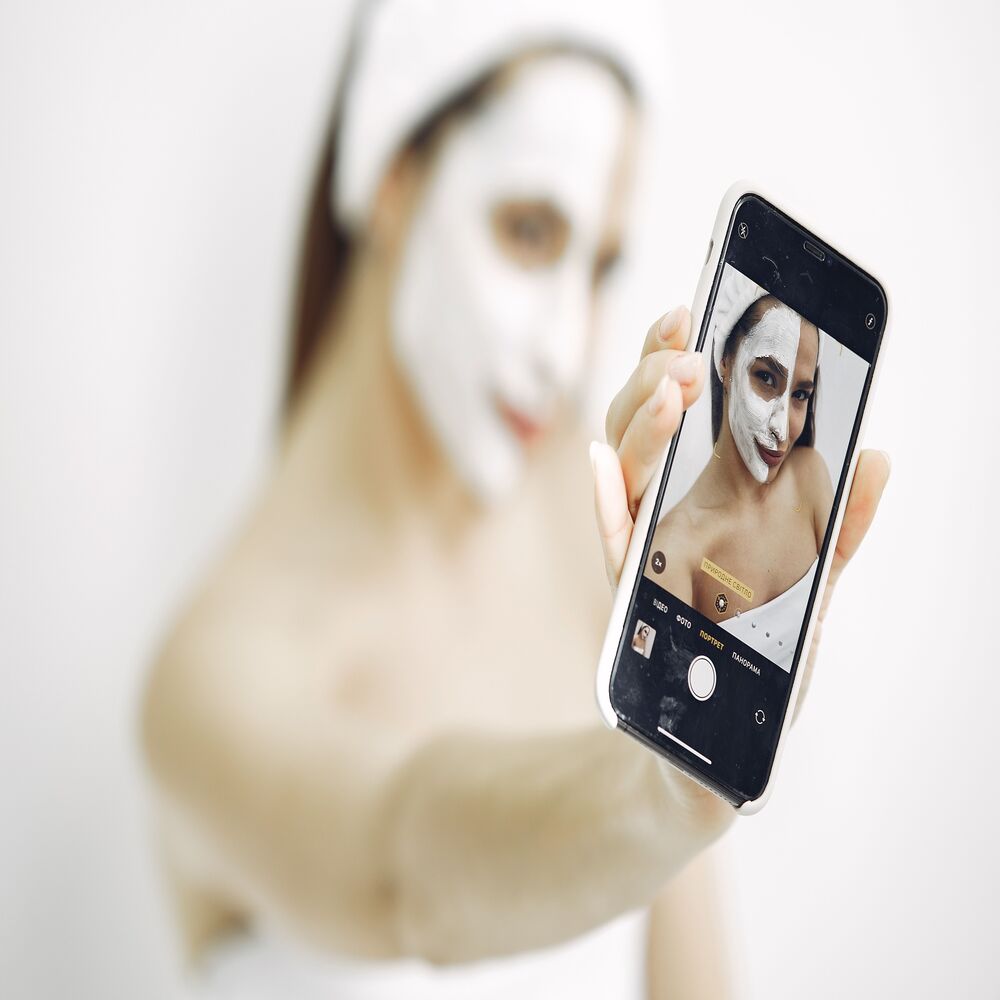 Khách hàng spa vui vẻ selfie khoe làn da sạch mụn sau liệu trình điều trị và để lại review tích cực